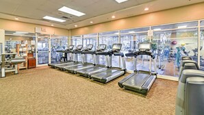 A gym with multiple treadmills, exercise equipment, and a view of the outside through large windows. - 7 Mi to Disney World: Condo w/ 2 Balconies + Pools (Kissimmee)