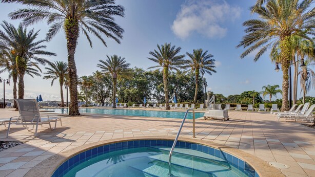 A swimming pool with palm trees and lounge chairs. - 7 Mi to Disney World: Condo w/ 2 Balconies + Pools (Kissimmee)