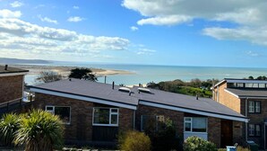 A residential area with houses overlooking a beach and the sea.