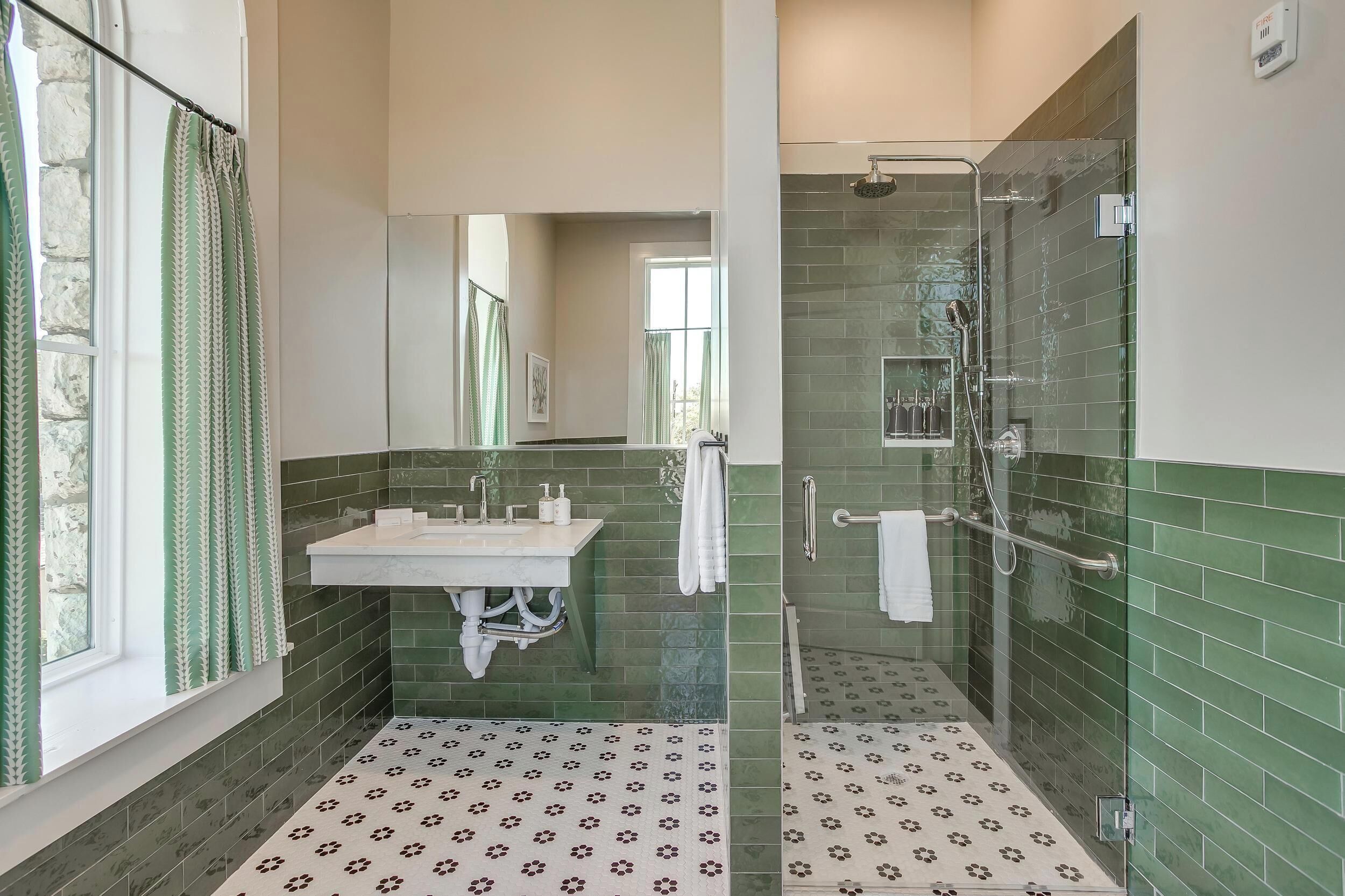 Une salle de bain équipée d’un lavabo, d’un miroir et d’un espace douche.