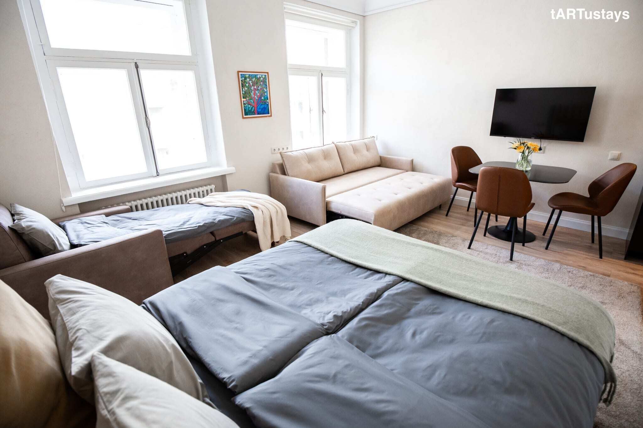 Une chambre à coucher moderne avec un lit, un canapé, un bureau et un téléviseur.