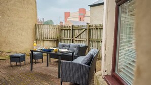 Un espace extérieur aménagé avec une table, des chaises et un canapé.