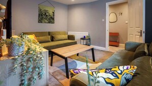 Un salon avec un canapé, une table basse et un radiateur.