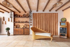 A room with a wicker chair, wooden shelves with various items, a wooden door, and a vending machine.