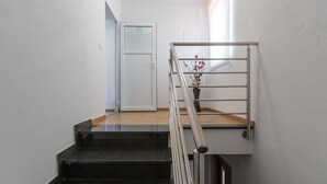 A staircase with a metal handrail, a wooden landing, and a door in the background. - Awesome apartment in Umag with WiFi (Umag)