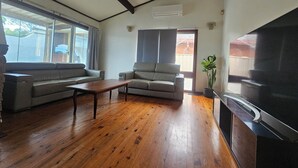 Una sala de estar con un sofá, una mesa de centro y un televisor de pantalla plana.