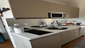 A modern kitchen with two sinks, a microwave, and a built-in oven.