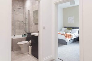 Une salle de bain moderne équipée d’une douche, de toilettes et d’un lavabo.