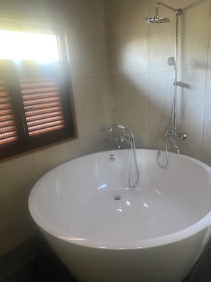 Een douche, handdoeken, zeep, toiletpapier