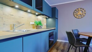 A modern kitchen with a built-in island, a sink, and a clock on the wall.
