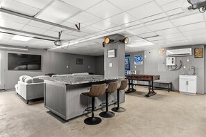 A modern bar area with a bar stool seating, a counter, and a bench.