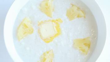 Un bol de porridge agrémenté de morceaux d'ananas.