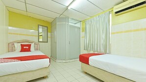 A hotel room with two beds, a mirror, a wardrobe, and an air conditioning unit. - Grand Heritage Hotel (Malacca City)