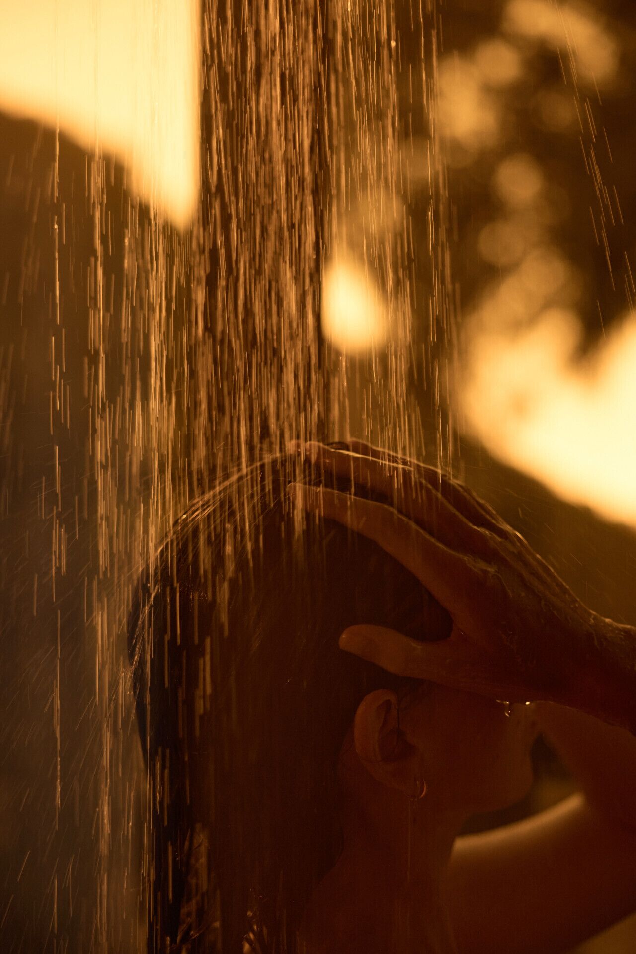 Une personne sous la douche, l’eau coulant sur son corps.