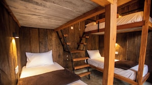 Eine rustikale Holzhütte mit Stockbetten und einer Treppe.