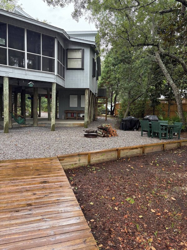 Un bâtiment à deux étages doté d’une terrasse couverte, d’un foyer extérieur et de coins salon en plein air.