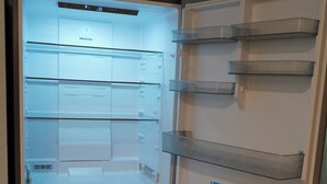 An open refrigerator with multiple shelves and a freezer compartment. - 2nd Floor Lakeview 2-Bedroom Condo in Geneva U4 (Geneva)