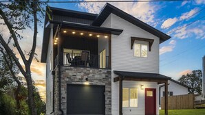 A modern two-story house with a stone facade, a garage, and a covered entryway. - Modern 2-bedroom house with WiFi, AC in Kimberling City (Kimberling City)