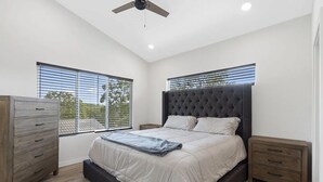 A bedroom with a large bed, a wooden dresser, a nightstand, and a ceiling fan. - Modern 2-bedroom house with WiFi, AC in Kimberling City (Kimberling City)