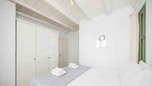 Ein Schlafzimmer mit einem Bett, einem Kleiderschrank und einer grünen Tür.