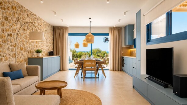 A modern living room with a sofa, dining table, and TV. - Villa Pollux - Two Bedroom Villa, Sleeps 4 (Gennadi)