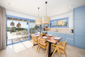 Una cocina moderna con comedor, ventanas amplias y vistas al exterior.