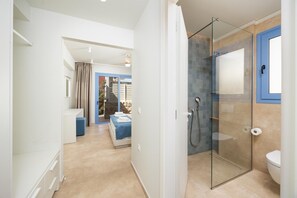 A modern bathroom with a glass shower enclosure, a toilet, and a sink.
