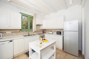 Eine moderne Küche mit weißen Schränken, einer eingebauten Mikrowelle und einem Edelstahlkühlschrank.
