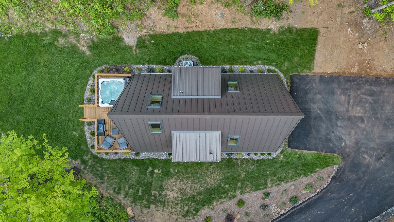 Una casa moderna de dos pisos con una amplia terraza, un jacuzzi y una piscina.