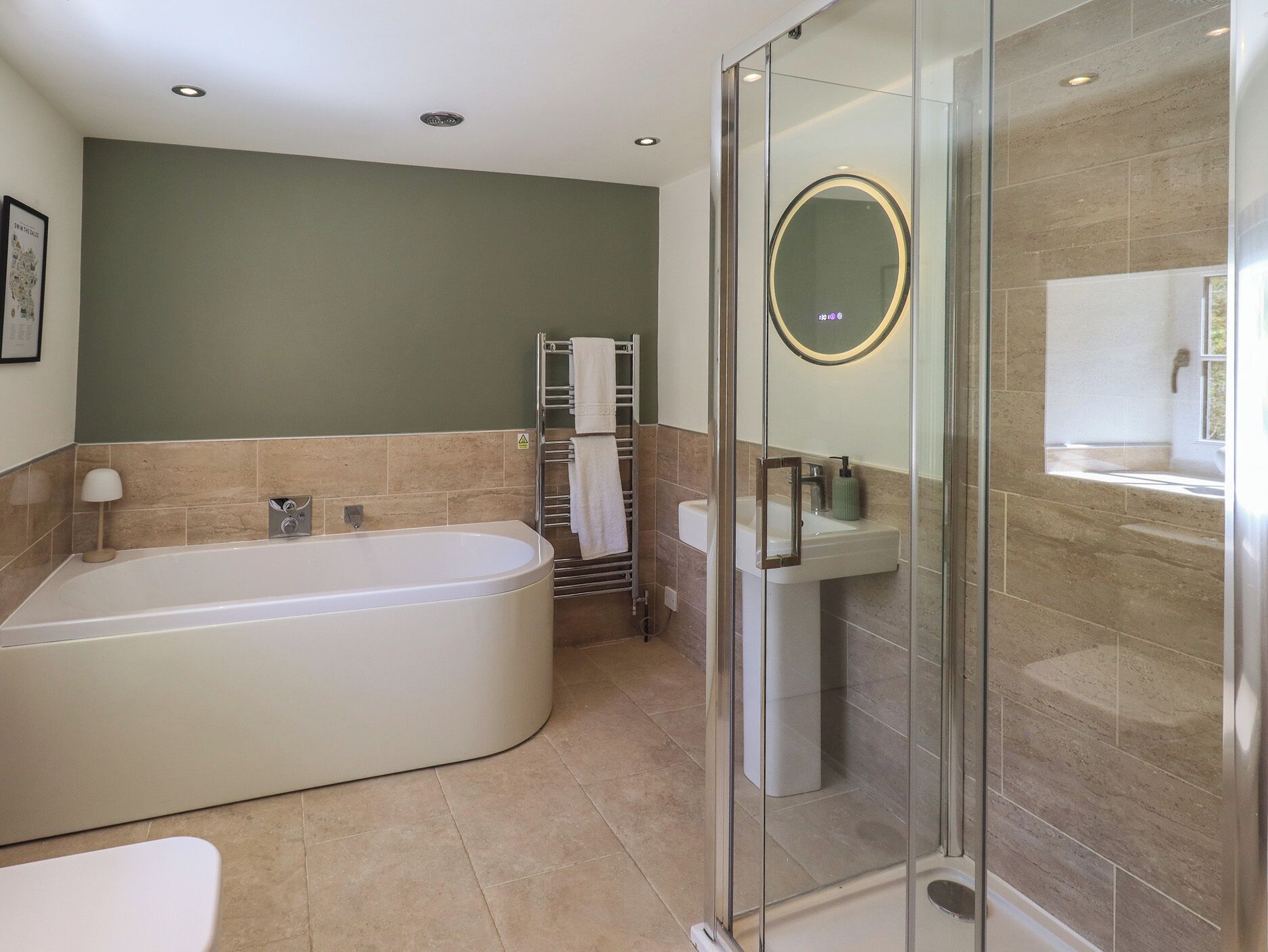 A modern bathroom with a freestanding bathtub, a glass-enclosed shower, and a sink with a mirror.
