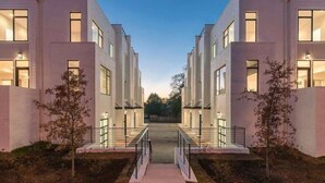 A modern building with a central walkway leading to a gated entrance. - Gulch Getaway - Rooftop deck & fire pit (Nashville)