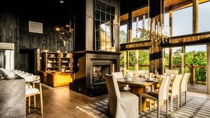 A spacious room with a large dining table, chairs, a fireplace, and a bookshelf. - Midnight Mtn-Skyline - Private pool & theater room (Sevierville)