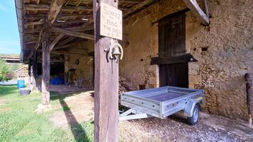 A rustic building with a wooden structure, a bell, and a sign that reads 'SONNEZ RING THE BELL'.