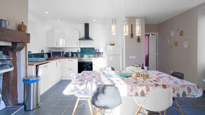 A modern kitchen with white cabinets, a microwave, and a dining area with a table set for four.