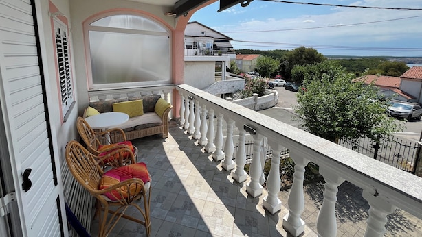 Un balcone con angolo relax, vista sulla strada e ringhiera.