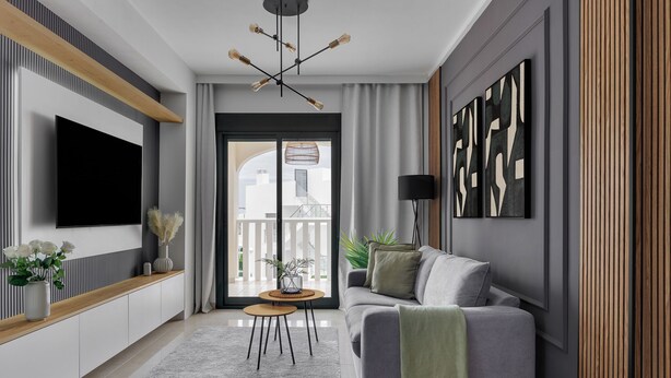 Una sala de estar moderna con un sofá gris, un televisor de pantalla plana montado en la pared, una mesa consola de madera con objetos decorativos, y un amplio ventanal con vistas a edificios.