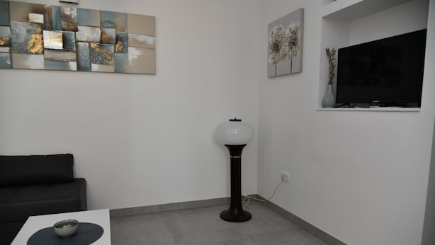 A modern living room with a white sofa, a coffee table with a bowl, a floor lamp, and abstract wall art. - A1 Apartment With Terrace, 1 min Walk to the Beach (Supetar)