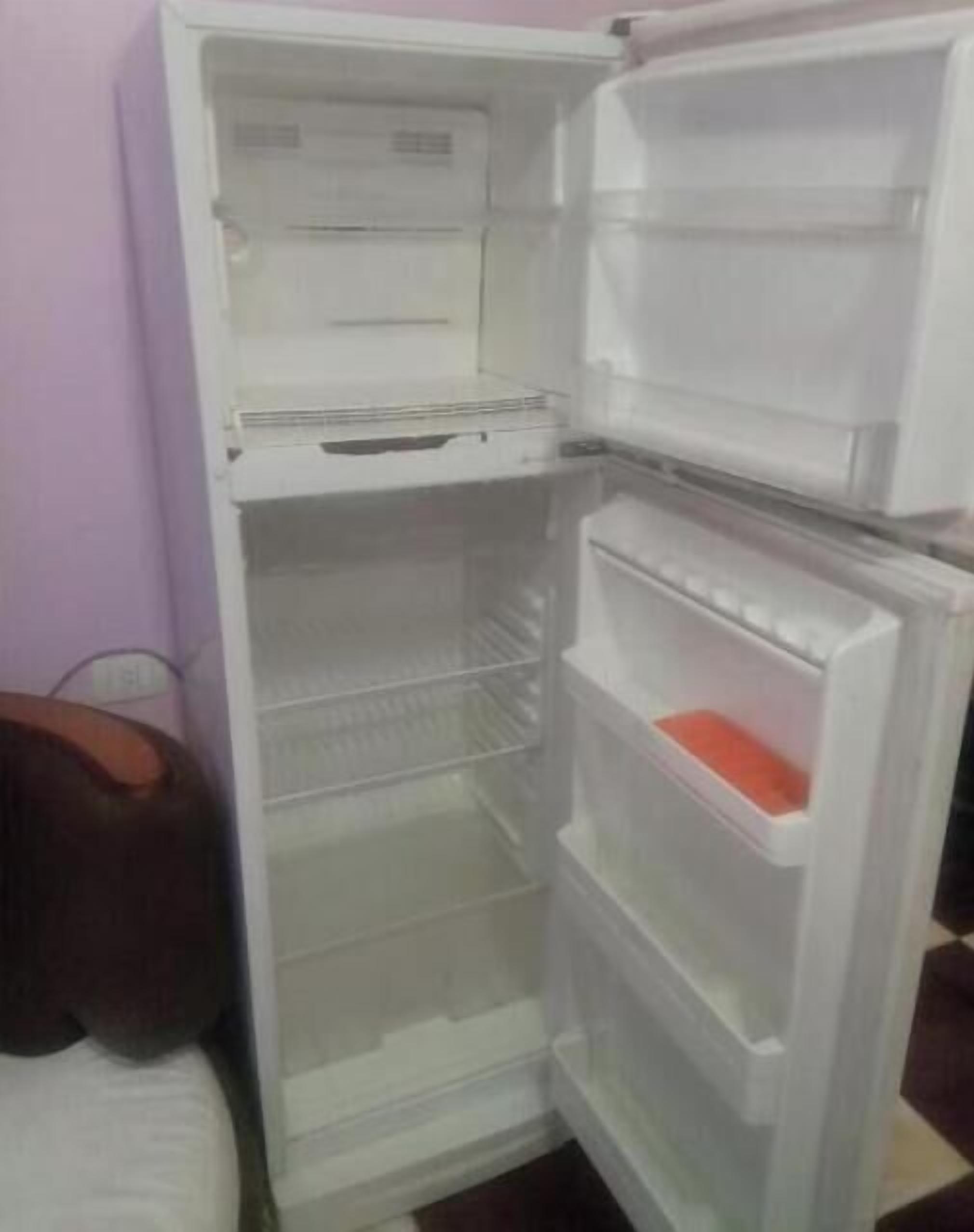 An open refrigerator with multiple shelves and a freezer compartment.