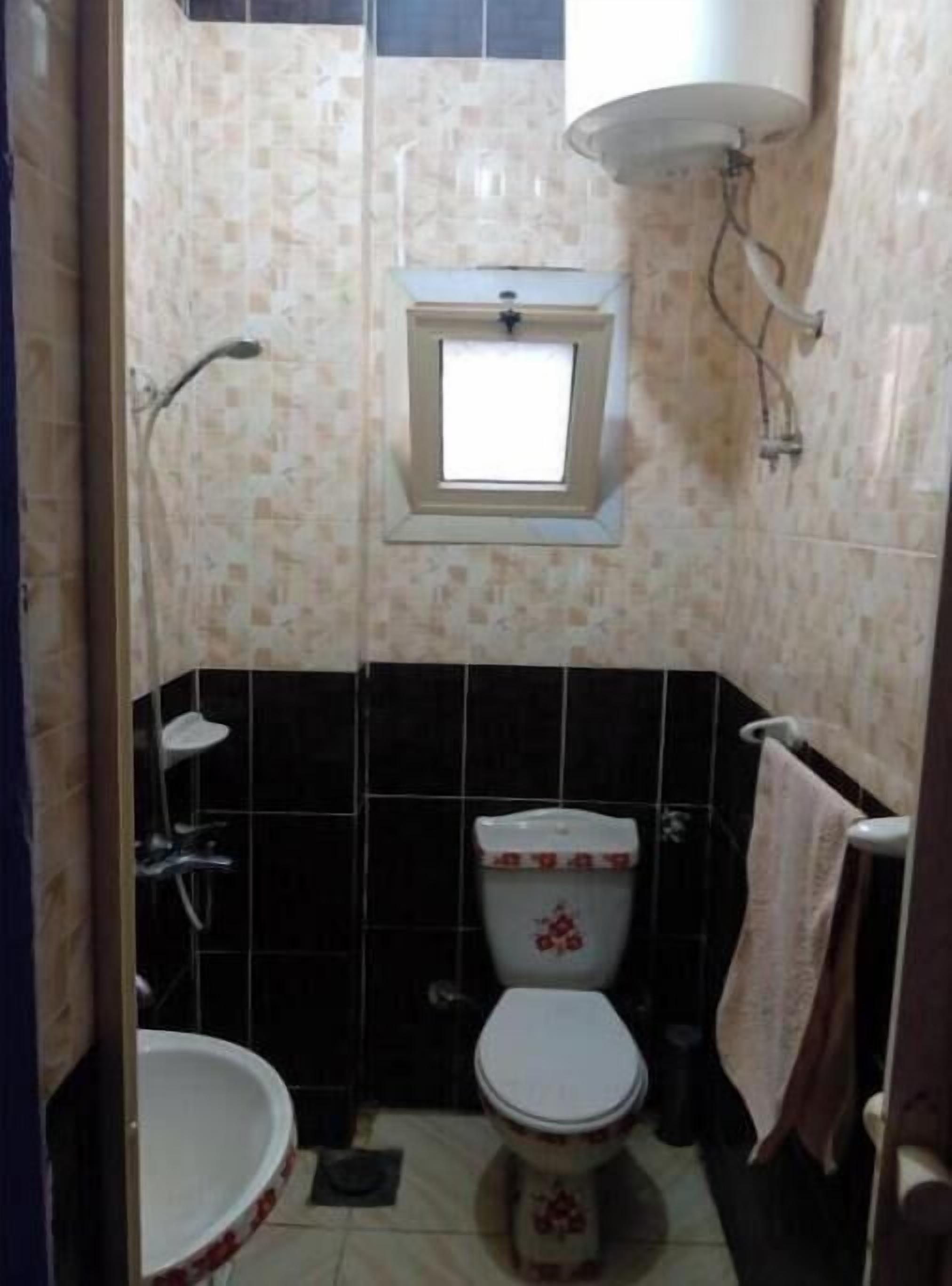 Ein kleines Badezimmer mit Toilette, Waschbecken und Dusche.