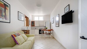 A compact living space with a kitchenette, a dining area, and a sofa. - GuestHost - Villa Safi: Apartment A (Ostuni)