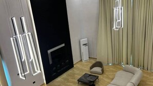 A modern living room with a sofa, armchair, and a fireplace. - 🌟 Luxurious 4-Bedroom Penthouse in Parkview, Ikoyi 🌟 (Lagos)