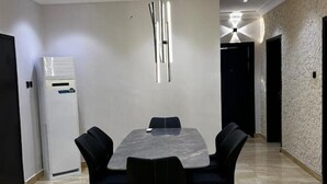 A modern dining area with a marble table and black chairs, a built-in air conditioner, and a textured wall. - 🌟 Luxurious 4-Bedroom Penthouse in Parkview, Ikoyi 🌟 (Lagos)