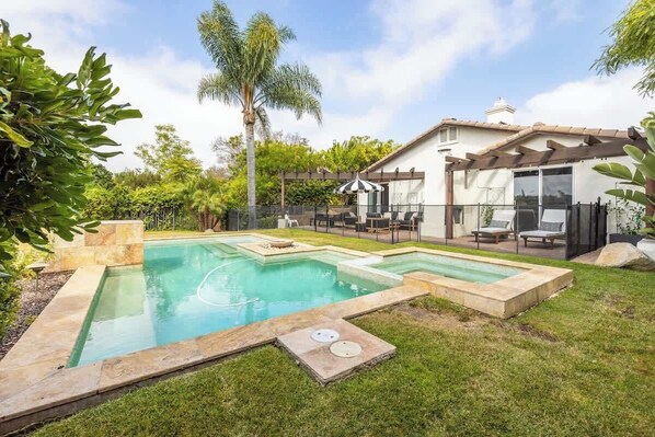 A backyard with a rectangular swimming pool, a pergola, and a patio area with outdoor furniture. - Private Hilltop Escape: Pool, Hot Tub, Near Beach (Vista)