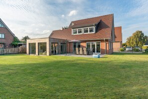 A two-story house with a brick exterior and a tiled roof. - Holiday Home 'Neeborg' with Private Terrace, Garden, and Wi-Fi (Zetel)