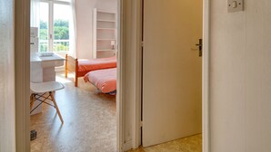 Ein Zimmer mit einem Bett, einem Schreibtisch und einem Stuhl.