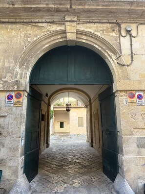 Ein gewölbter Eingang mit einem Kopfsteinpflasterweg hindurch.