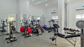 Ett gym med olika typer av träningsutrustning, inklusive löpband, motionscyklar och styrketräningsmaskiner.
