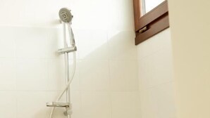 Een douche met een handdouche en een wandmengkraan.