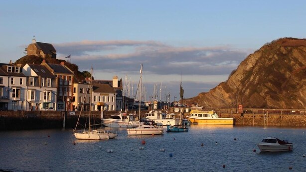 A harbor with boats, a lighthouse, and buildings along the waterfront. - 2 Bed in Ilfracombe (oc-f31994) (Ilfracombe)