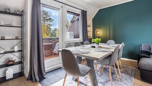 Un espace repas comprenant une table, des chaises et une vue dégagée grâce à de grandes fenêtres.